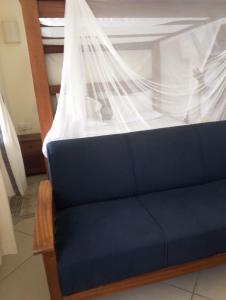 a blue couch with a veil on top of it at Beach front Spacious Studio in Malindi +16 photos