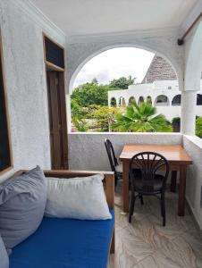 a room with a bed and a table and a window at Beach front Spacious Studio in Malindi