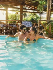 a man and a woman in a swimming pool at Pousada Estância Mineira in Guapé +28 photos