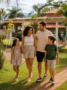 a family walking down a path in a yard at Pousada Estância Mineira in Guapé