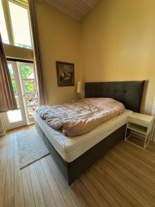 a bedroom with a bed and a chair and windows at Bøtøstrand anneks in Bøtø By