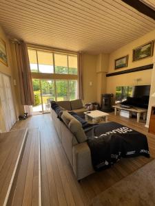 a living room with a couch and a tv at Bøtøstrand anneks in Bøtø By
