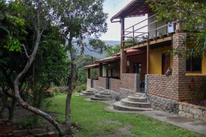 a brick house with trees in front of it at Vila Clara do Capão in Vale do Capao