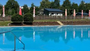 a large blue swimming pool with umbrellas at Na Kameni in Rožnov pod Radhoštěm