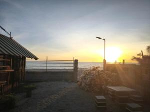 Sonnenuntergang über einem Strand mit Straßenlaterne und dem Meer in der Unterkunft Lagman Beachfront in Iba + 6 Fotos