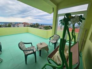 a room with a balcony with chairs and a table at Paralax Hotel in Varna City