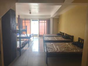 ein Zimmer mit drei Etagenbetten und einem Fenster in der Unterkunft Lagman Beachfront in Iba