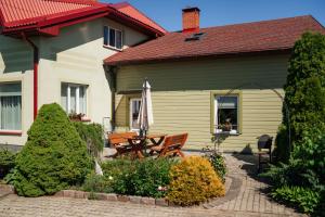 a house with a picnic table in front of it at Zaļais Stūrītis - Semi-Detached Holiday Home with Private entrance & Indoor Sauna in Liepāja