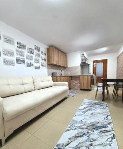 a living room with a white couch and a kitchen at Sweet Home in Pogradec