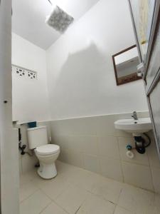ein Badezimmer mit Toilette und Waschbecken in der Unterkunft Lagman Beachfront in Iba