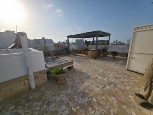 a patio with a bench and a pavilion on a roof at Cozy Almadies l'original in Dakar