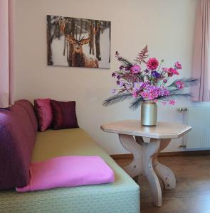a living room with a couch and a table with flowers at Ferienhaus Hirterhütte in Abtenau