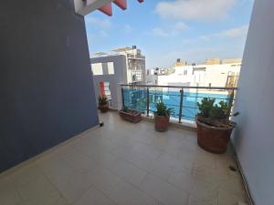 a balcony with potted plants on top of a building at Cozy Almadies l'original in Dakar