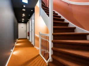 a hallway with a staircase with orange carpet at Hotel BonBon & BonBon Budget in Rotterdam +26 photos
