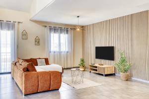 a living room with a couch and a tv at Villa Ô Ti Paille-en-queue - 14 voyageurs in Saint-Joseph