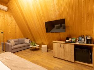 a living room with a couch and a flat screen tv at Reserve Resort Lagodekhi in Lagodekhi