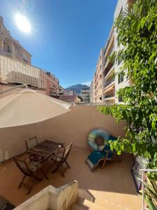 a patio with a table and chairs and an umbrella at Perfectly located holiday place in Beaulieu-sur-Mer