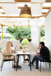 a group of people sitting at a table at MaDaM Essence in Nei Poroi