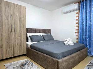 a bedroom with a bed with a wooden cabinet at Sweet Home in Pogradec