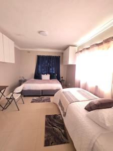 a bedroom with two beds and a window at Mutare Fairbridge Executive Suites in Umtali