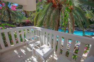 a balcony with a chair and a swimming pool at Deluxe Rooms Pet Friendly in Fethiye