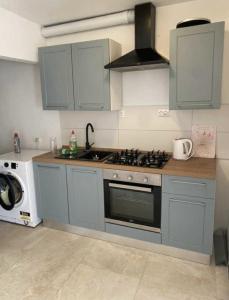 a kitchen with blue cabinets and a stove top oven at Villa Klara in Gedići