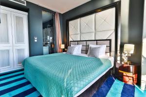 a bedroom with a large bed with a green bedspread at Azure Coast Deluxe Residence - Budva Seafront Living Suites in Bečići