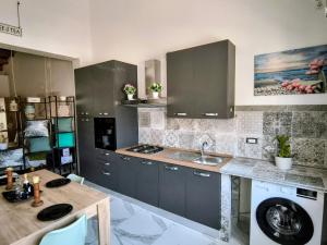 a kitchen with a sink and a washing machine at THE KING'S LOFT Loft del Rè Sebi in Villasmundo