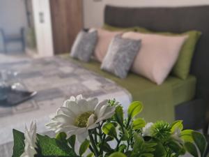 a room with a couch and a table with a flower at THE KING'S LOFT Loft del Rè Sebi in Villasmundo