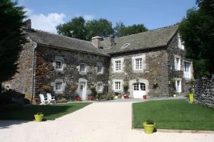 an old stone building with a grass yard at La Maison De Suzanne in Arcomie