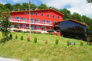 a large red building on top of a hill at Семеен хотел Forest Retreat Mountain Resort in Kyustendil