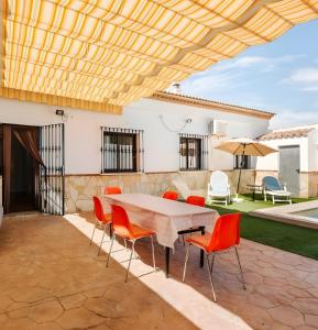 a patio with a table and chairs and an umbrella at Casa Miró in Humilladero