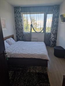 a bedroom with a bed and a large window at Семеен хотел Forest Retreat Mountain Resort in Kyustendil