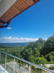 a view of the mountains from the balcony of a house at Семеен хотел Forest Retreat Mountain Resort in Kyustendil +1 photo