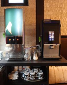 a coffee machine sitting on top of a counter with cups at Hotel Lent in Maribor