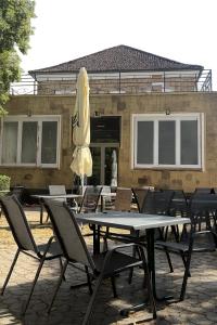 a table with chairs and an umbrella in front of a building at Templer zum Gasthof in Lochenhaus