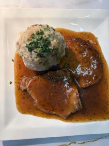 a plate of food with meat and a ball of gravy at Templer zum Gasthof in Lochenhaus