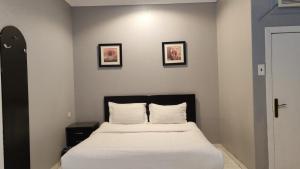 a bed in a room with three pictures on the wall at مساكن صفوه الديار in Abha