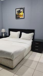 a bed with white sheets and a picture on the wall at مساكن صفوه الديار in Abha