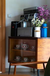 a cabinet with cups and flowers on top of it at Cudne Manowce in Wisła