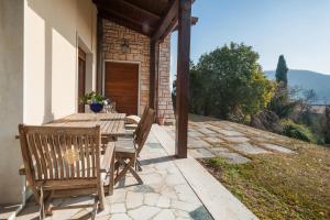 a wooden table and chairs on a patio at Welcome Traveller VILLA LEDA in Garda