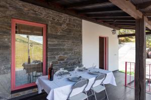 a table with a blue table cloth and chairs on a patio at Feel Discovery Casa Fonte do Lagar in Desejosa