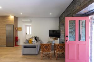 a pink door in a living room with a couch at Feel Discovery Casa Fonte do Lagar in Desejosa