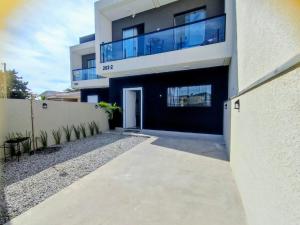 a large building with a walkway in front of it at Sobrado Matinhos 480 m da praia l novo l central 3quartos in Matinhos