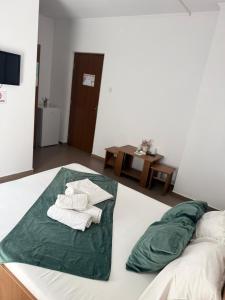 a bedroom with a bed with towels on it at Vila Cristina in Mamaia Sat/Năvodari