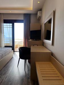 a hotel room with a desk and a bed and a television at Hotel Lungomare in Vlorë