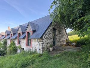 a stone house with solar panels on it at Le petit Valet in Saint-Clément