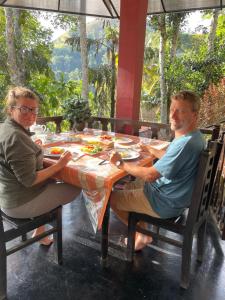 a man and woman sitting at a table at Ella Shali's home in Ella