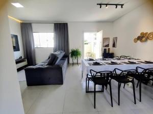 a living room with a couch and a table and chairs at Sobrado Matinhos 480 m da praia l novo l central 3quartos in Matinhos