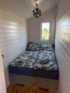 a bed in a tiny house with a window at BananaHouse Junior in Kruszwin +39 photos